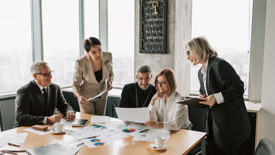 A group of people are working together in a law firm analyzing various documents and metrics to signify good productivity in the law firm billing process