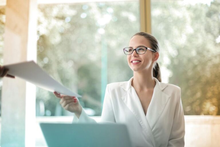 A person hands a document to another person in an office.