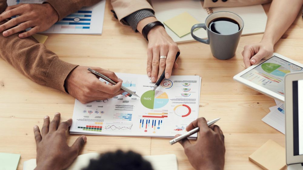 People reviewing documents with metrics and graphs at a table