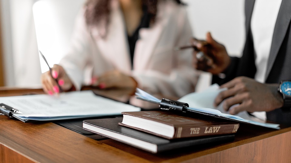 Two law professionals collaborating on financial paperwork in an office setting.