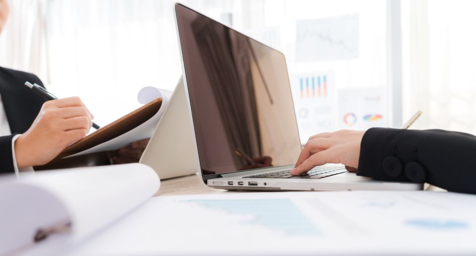 Two business professionals reviewing data on a laptop in a law office