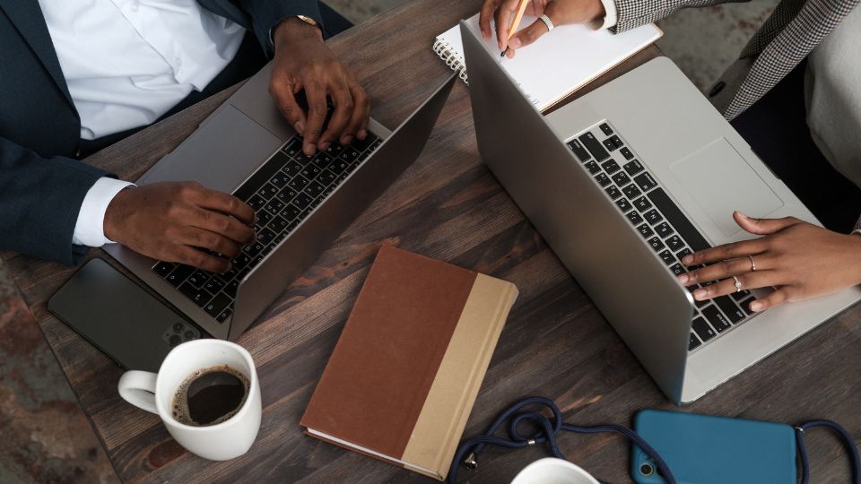Two business professionals working on their laptops.