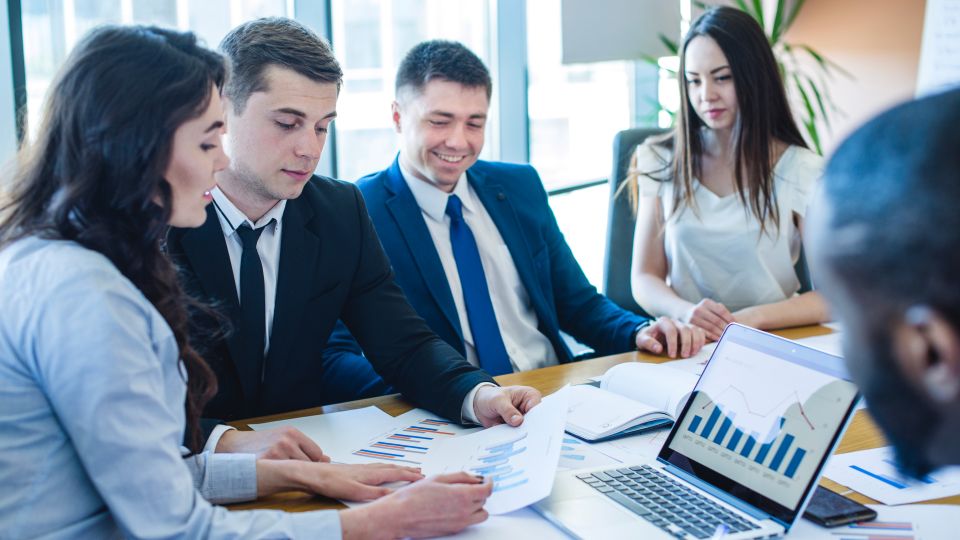 Business professionals collaborate at a meeting table
