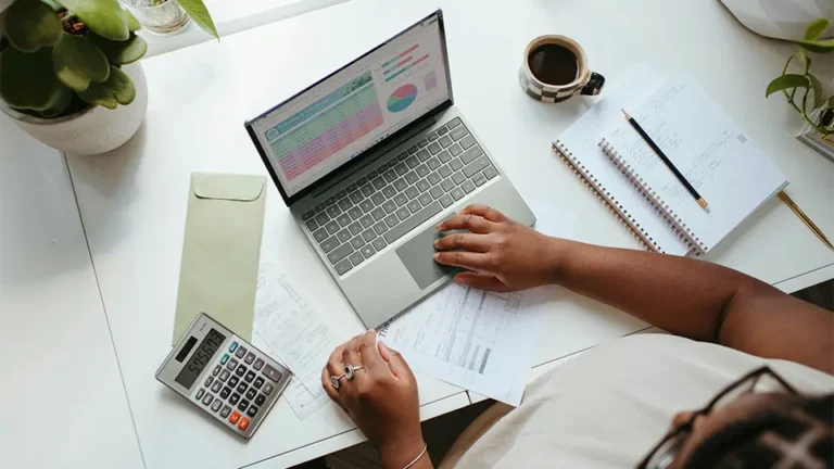 Woman using laptop on clean modern desk.